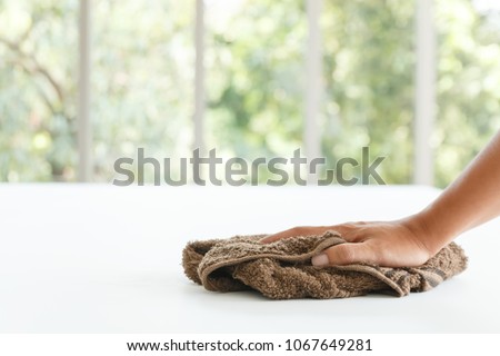 close up hand of maid cleaning white table on blur background Royalty-Free Stock Photo #1067649281