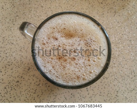 Flat Lay of Flat White Coffee with foam bubbles in a mug on the table.  