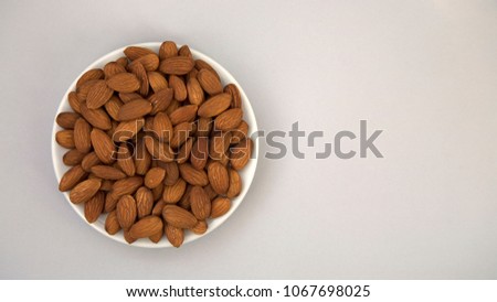 Raw Natural Organic Almonds Nuts on White Plate on Grey Background Top View Healthy Food for Life Natural Light Selective Focus
