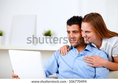 Portrait of a beautiful couple using laptop together at living room at home indoor