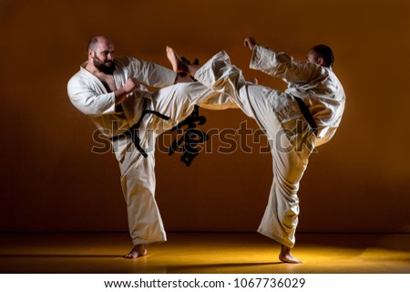 Two karate men fighting in a indoor dojo. With the word kyokushinkai on the background. Which means: the last truth associated. Royalty-Free Stock Photo #1067736029