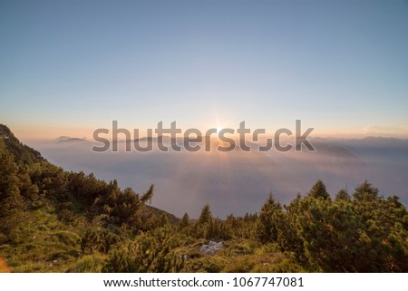 sunset in mountain with haze above garda lake