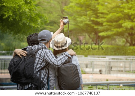 Multiethnic Traveling Tourist backpackers taking photo outdoors with friend in summer park. photographer traveler lifestyle concept.