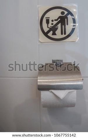 close up tissue paper roll in toilet with icon  of do not put tissue paper sheet into the toilet bowl