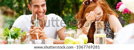 Happy man drinking water during a meeting with his girlfriend on the terrace