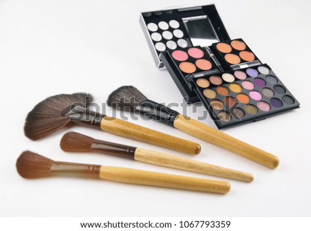 The abstract art design background of eyeshadow pallette and make up brush set put on white background.warm light tone,blurry light around.
