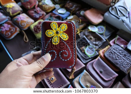 Group colorful Wallet of Leather skin on wooden background.Black purse with British money.Different hand made leather man accessories on wooden background.