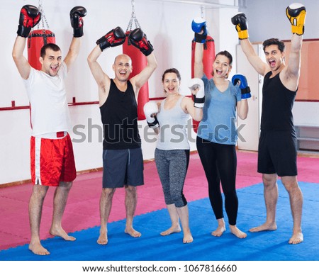 Portrait of  friendly females and adult males training in boxing gloves