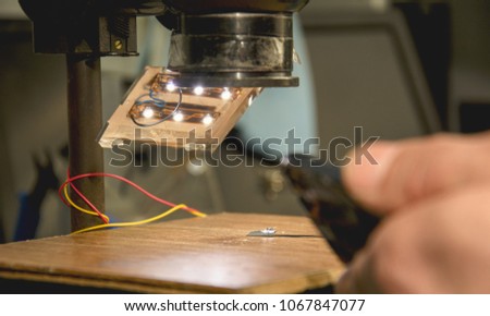 The engineer repairs the phone, soldering iron, board, working tool, workshop, men's hands, phone repair, phone repair, microscope, workflow, preparation for phone repair, microscope