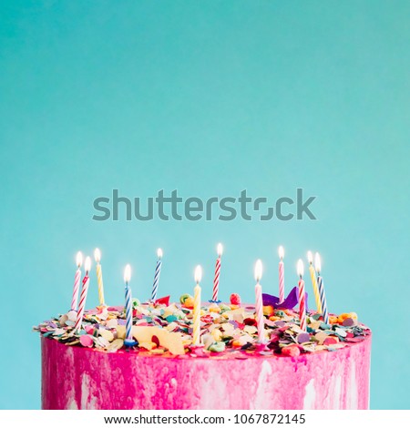 Pink birthday cake over blue background