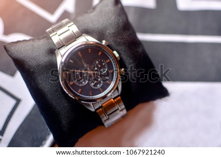 Wrist watch on a black satin pillow