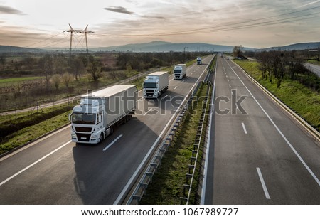 Caravan or convoy of trucks in line on a country highway Royalty-Free Stock Photo #1067989727