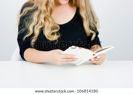A girl with long blond hair reading a book