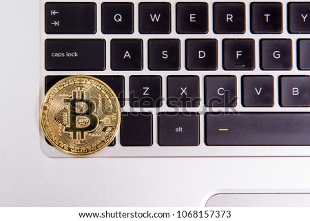 Cryptocurrency physical golden bitcoin coin on keyboard