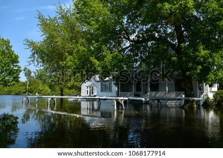 Buildings and houses on Toronto island when it flooded in 2017, water, trees, lake shore. 
