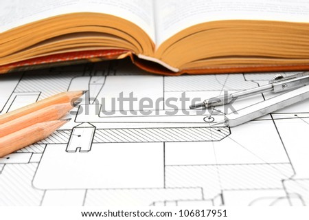 The book, pencils and compasses on the drawing.