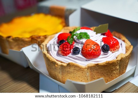 Cool fresh Fruity berry cheese tart; blueberry cream favour topping with stawberry, blueberry take it out from the paper box.