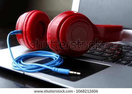 Photo of stereo headphones and a laptop computer