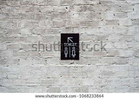 Toilet modern sign label on concrete brick wall