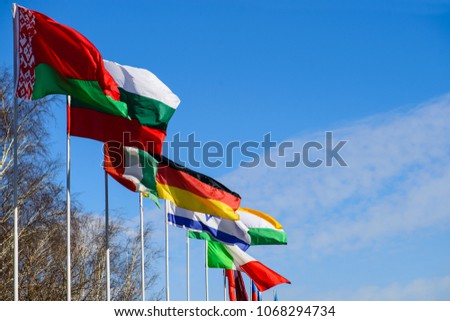 International summit. Flags of different countries blowing in the wind on the sky background

