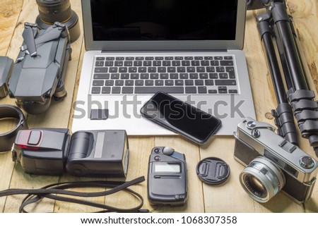 top view of work space photographer and travel concept with camera, drone,flash, computer laptop on wooden background