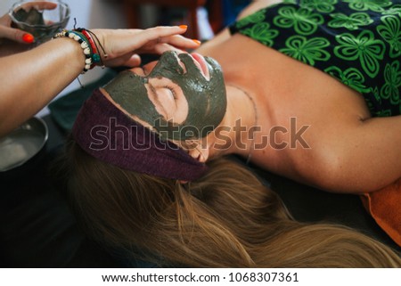 The girl doing the facial massage. The girl put a clay mask on the face. The cream on the face. Ayurvedic treatment. Spa treatments in Asia. Ayurveda salon
 Royalty-Free Stock Photo #1068307361