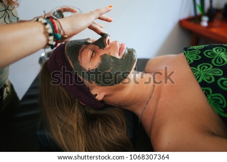 The girl doing the facial massage. The girl put a clay mask on the face. The cream on the face. Ayurvedic treatment. Spa treatments in Asia. Ayurveda salon
 Royalty-Free Stock Photo #1068307364