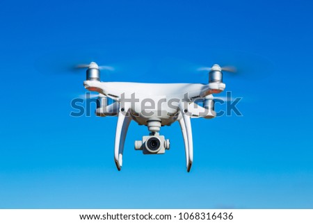 drone flying in blue sky takeing pictures and films