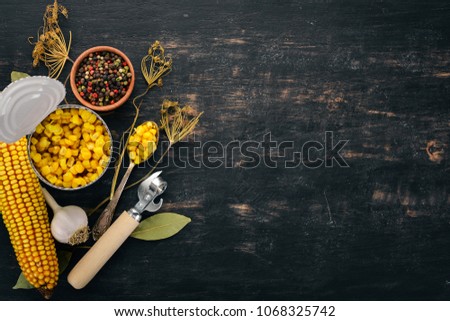 Pickled corn in a jar. Stocks of food. Top view. On a wooden background. Copy space