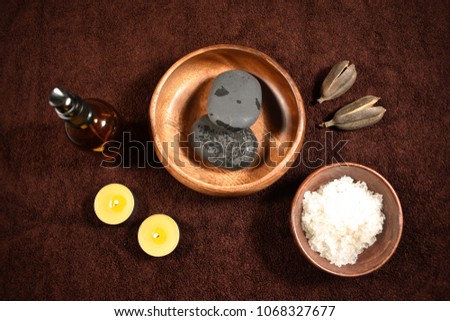 Brown wellness set stock images. Wellness setting. Sea salt in bowl, lava stones and candles on a brown textured background. Wellness brown background. Spa still life images
