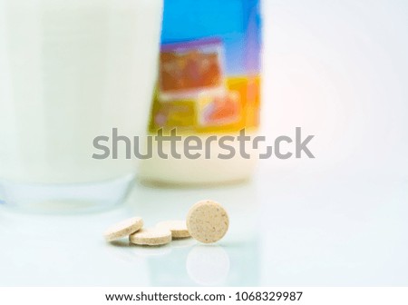 Sweetened flavored milk tablets and one glass of milk and milk bottle on white background. Calcium food products from cow milk for healthy bone.