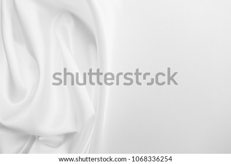Smooth elegant wavy white satin silk luxury cloth fabric texture, abstract background design. Copy space