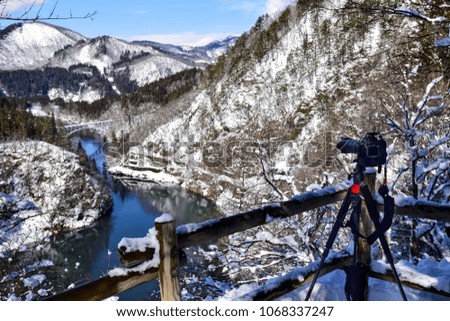 The photographer was preparing DSLR camera for shooting the picture of the railroad and Tadami river in winter. Tadami river is the popular place for the tourist who visit Fukushima prefecture. 