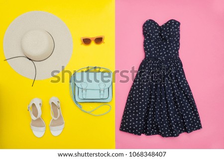 Fashionable concept. Female summer wardrobe. Straw hat, sundress, handbag and shoes. Yellow and pink
 background, top view