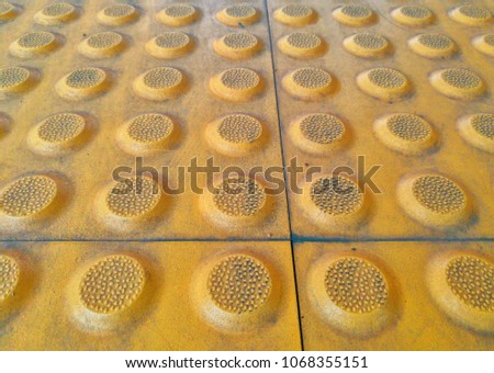 Yellow Braille Block on train station, Dirty Braille Tile, Braille Block for Blinds Handicap, close up rough tactile