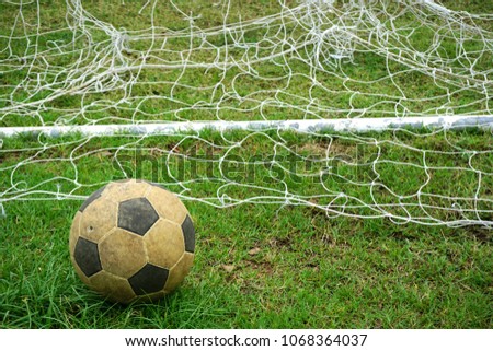 Old soccer ball on the grass