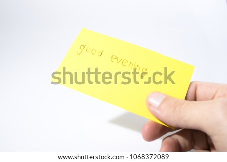 Good evening handwrite with a hand on a yellow paper compsoition