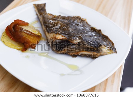 Closeup of gourmet restaurant dish of fried flounder with caramelized vegetables