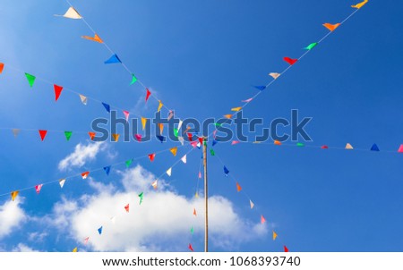 colorful of Thai style fancy flag strips on bright blue sky background that is made for faith or buddhist festival in Thailand