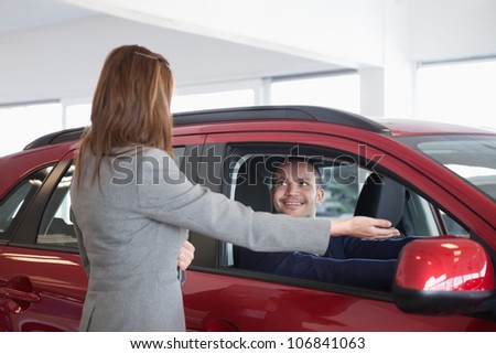 Businesswoman presenting something to a man in a dealership