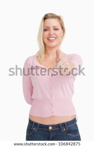 Joyful woman placing her thumbs up against a white background