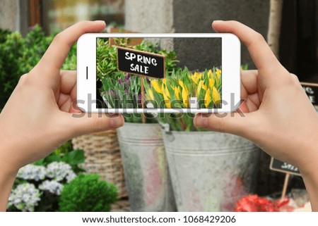 Woman is making a photo of flowers on the phone