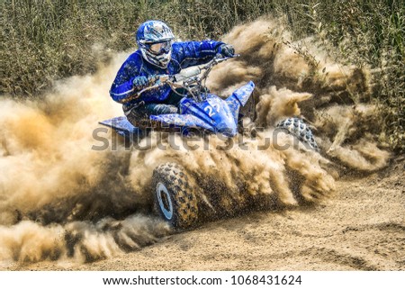 ATV rider creates a large cloud of dust Royalty-Free Stock Photo #1068431624