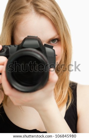 Close up of a woman holding a camera against white background
