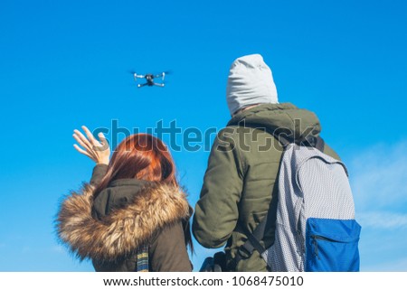 Two couple taking a selfie with a drone, drone navigating