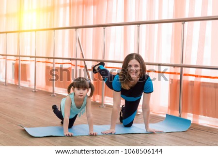 Parents and children go in for sports. Young mothers and their daughters do gymnastics and do yoga.