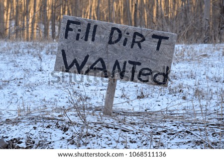 Fill Dirt Wanted sign in a snowy field. 