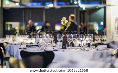 Decorated table on a gala dinner party with wine glasses and blurred out background Royalty-Free Stock Photo #1068521558