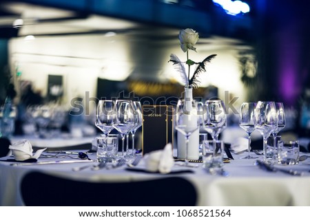 Decorated table on a gala dinner party with wine glasses and blurred out background Royalty-Free Stock Photo #1068521564