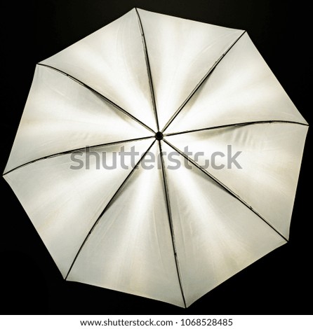 A view of the illuminated photo umbrella - a light softener - black background